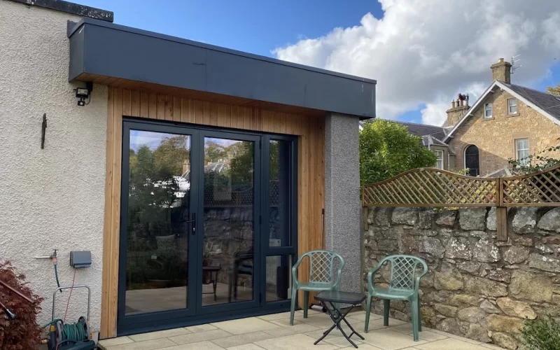 Contemporary garden extension featuring sliding glass doors and outdoor seating area.