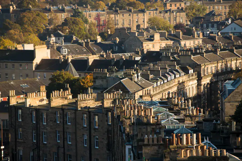 Victorian terraced houses with chimneys and pitched roofs in a picturesque urban setting.