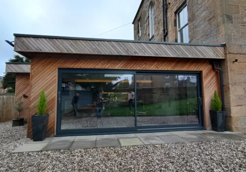 Bright, modern extension designed by ABC Architecture with wood facade and generous glass frontage.