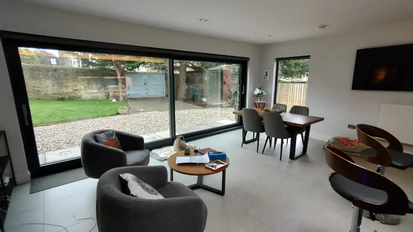 Spacious living area featuring large glass doors overlooking a private garden, ideal for modern home interiors.