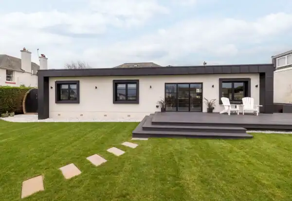 Stunning modern house featuring sleek black window frames and a spacious outdoor deck, designed by ABC Architecture.