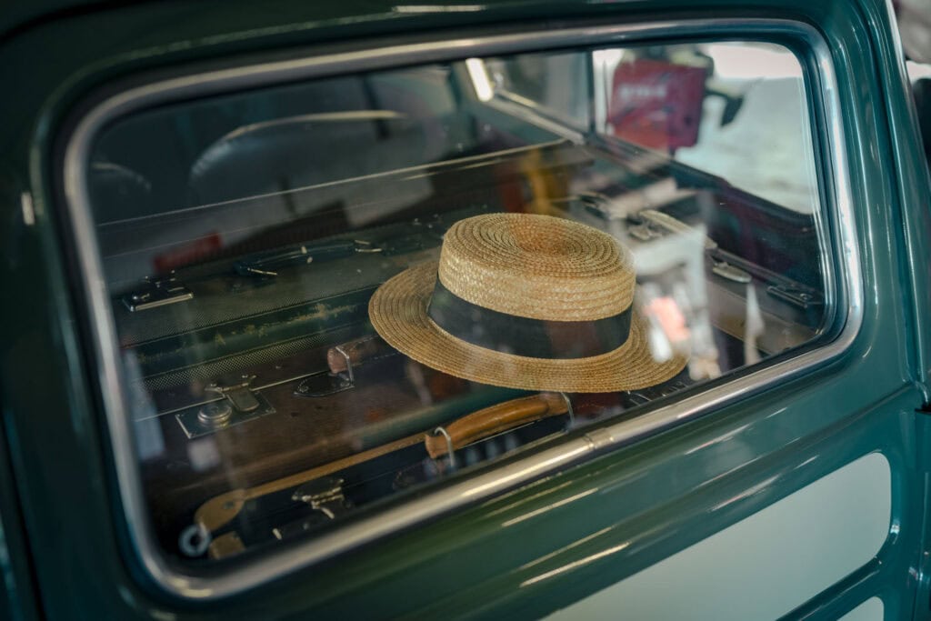 Oldtimer mit altem Strohhut hinter der Heckscheibe