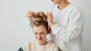 Une mère fait les cheveux de son enfant