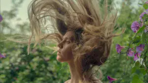 femme relevant la tête cheveux en l'air dans la nature