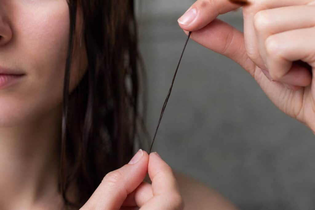 Une femme tient des cheveux cassants avec Biocoiff