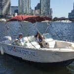 Boat4Hire Melbourne boat on water with city skyline in background.