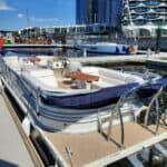 Luxury boat rental in Melbourne with city skyline view.