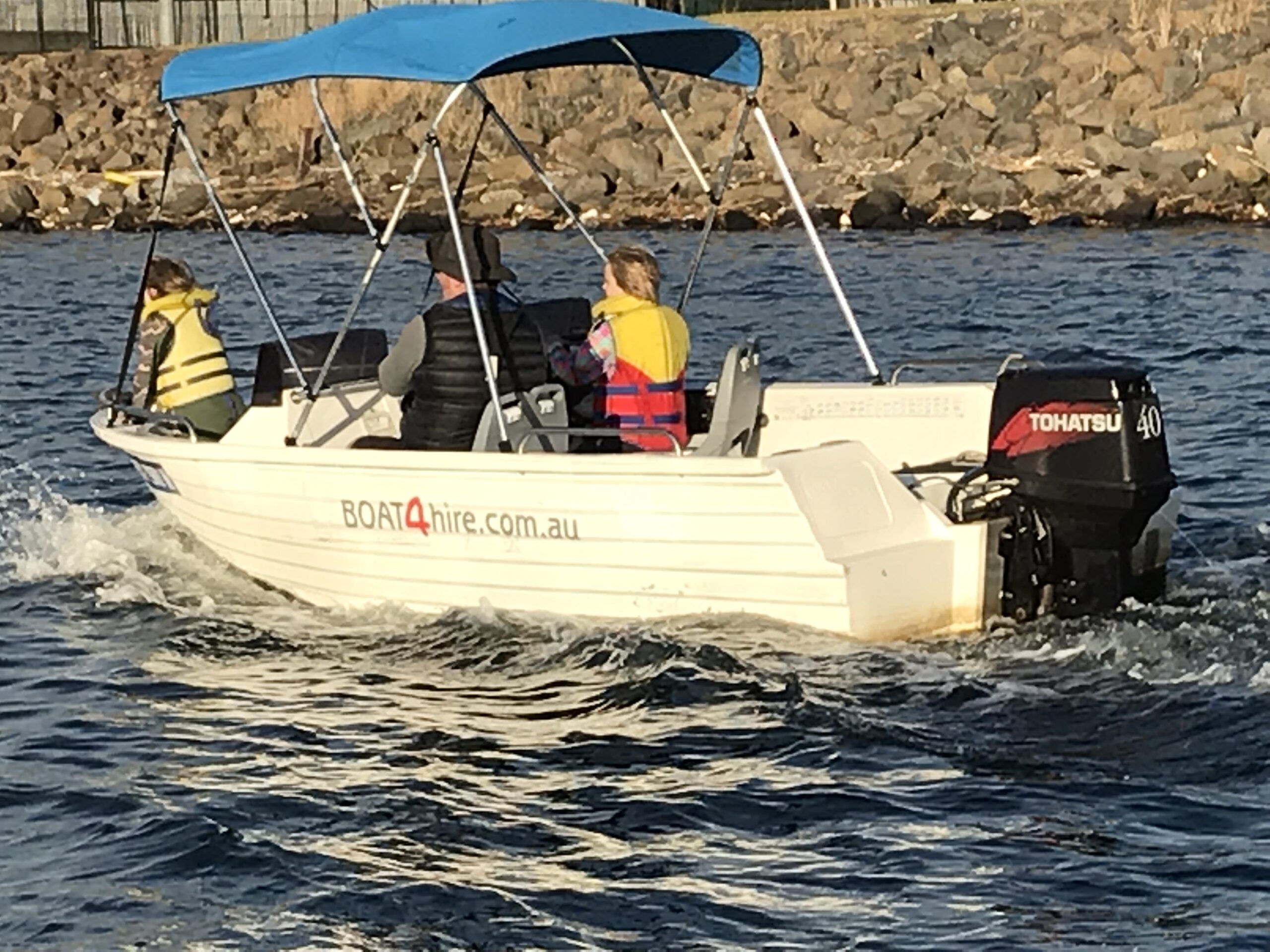 Family enjoying a pet-friendly boat ride on Melbourne waters.