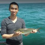 Man holding a fish on a boat in Melbourne waters.