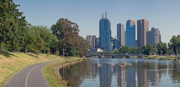 Melbourne city skyline with river and park in foreground.