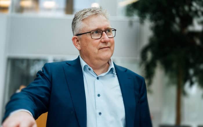 Mand i forretningsdragt med briller ser tænksom ud.
