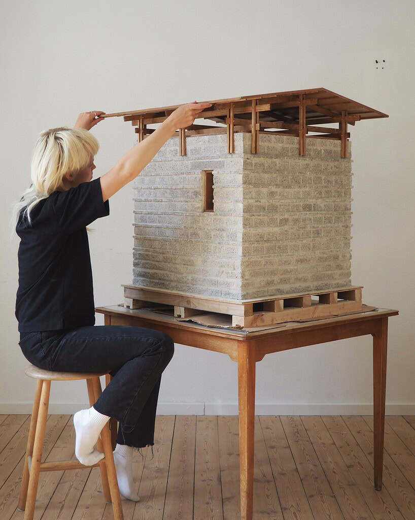 Model af arkitektonisk model af boligbyggeri på træbord.