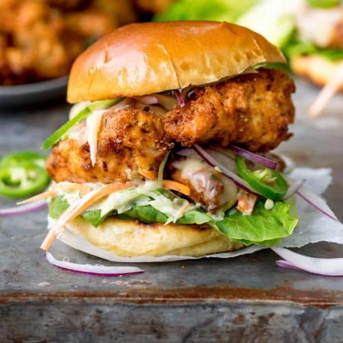 Delicious chicken burger with fresh vegetables and crispy fried chicken on a bun.
