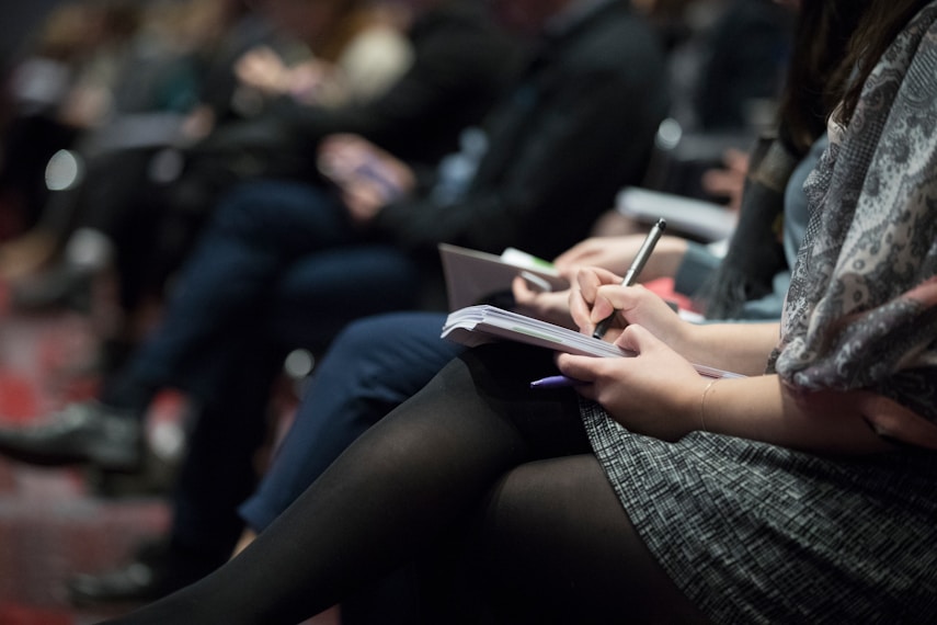 Audience members taking notes at an event