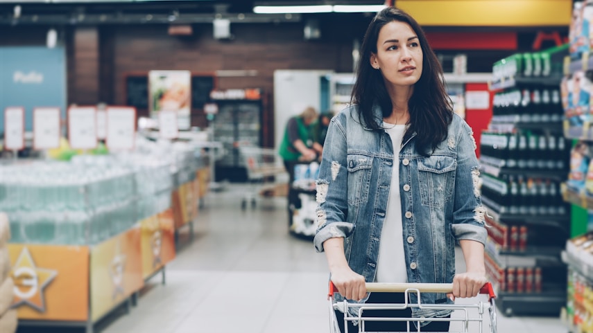 Woman pushing a shopping trolley through a supermarket