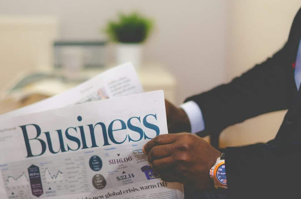Person reading business newspaper with focus on entrepreneurship in UAE.