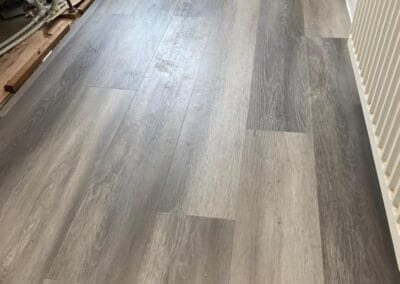 Grey vinyl bathroom flooring with textured wood finish.