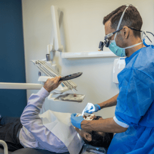 Brisbane CBD dentist treating a patient and demonstrating how to floss and care for dental implants