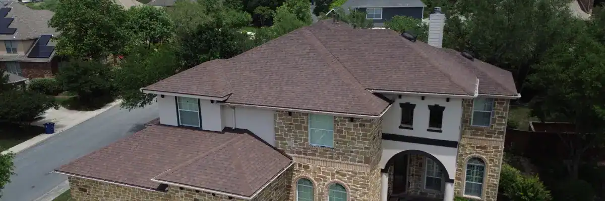 Freshly installed architectural shingle roof on a stone facade home, demonstrating added curb appeal and marketability tied to how much does a new roof add to home value by Dolan Roofing & Construction in San Antonio