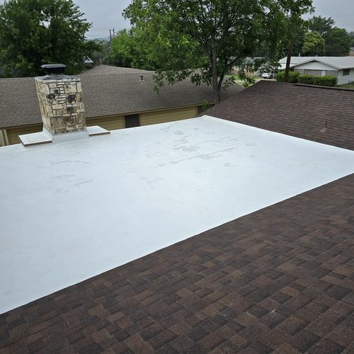 TPO membrane flashed around a stone chimney on a flat roof, Chimney Leak Repair and Roof Replacement in Kerrville, TX by Dolan Roofing and Construction