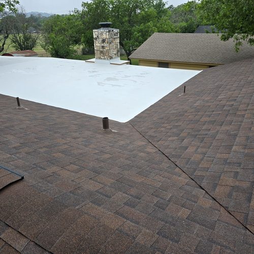 Asphalt shingle roof meeting a white TPO flat roof section, Roof Replacement With TPO Upgrade in Kerrville, TX by Dolan Roofing and Construction