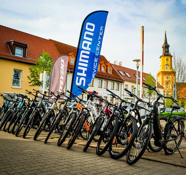 Fahrradservice Winkler in Templin Fahrräder und Shimano-Service-Flaggen vor Fahrradgeschäft in Templin.