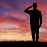 Independent male figure saluting during sunset, symbolizing strength and resilience in legal matters, representing Farr Law Firm’s commitment to client dedication and professional law services.