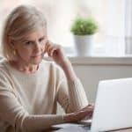 Concerned woman reviewing legal documents on a laptop, representing legal consultations and support from Farr Law Firm.