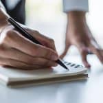 Legal professional writing notes in an office setting, symbolizing legal documentation and legal services.