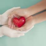 Compassionate healthcare provider holding a red heart shaped object, symbolizing care and dedication in medical and legal support services.