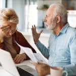 Overwhelmed senior couple discussing legal documents with an attorney at home, stressing the importance of estate planning and elder law.