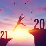 Jumping from 2021 to 2022 sunset at dawn, symbolizing transition and new beginnings, with silhouettes of birds flying, emphasizing optimism and progress; ideal for legal or motivational content.