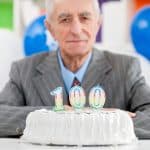 Celebrating 100th birthday with cake and candles, highlighting experience and dedication of Farr Law Firm in elder law, estate planning, and probate services.