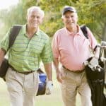 Older men walking on golf course with golf bags, representing legal support and advocacy for seniors.