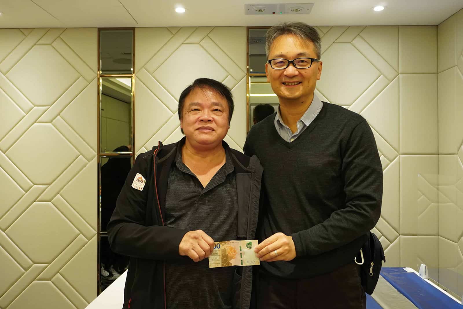 ALT：兩位男士在傢俬佬設計訂造公司簽約，展示專業服務與合作信任。.
