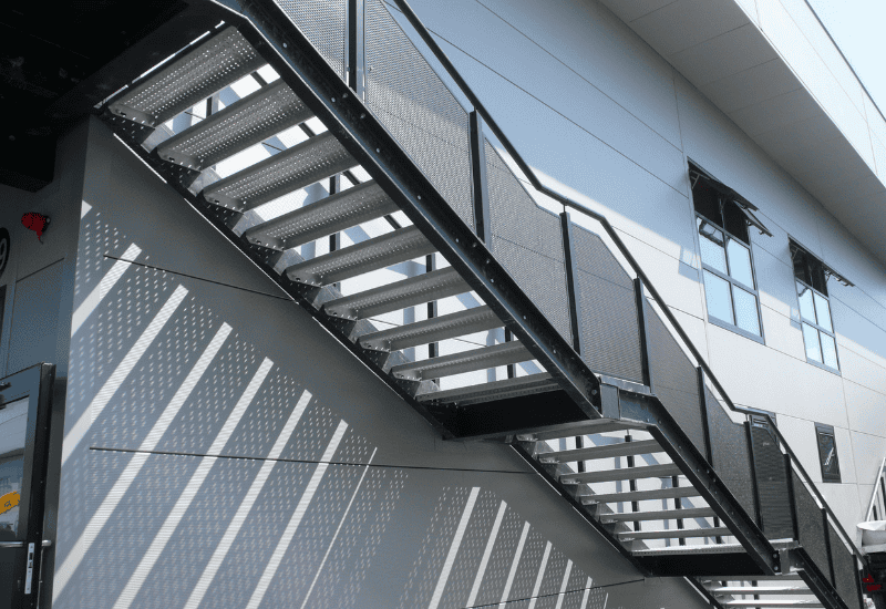 Perforated Metal stair threads at side of building - external stairway