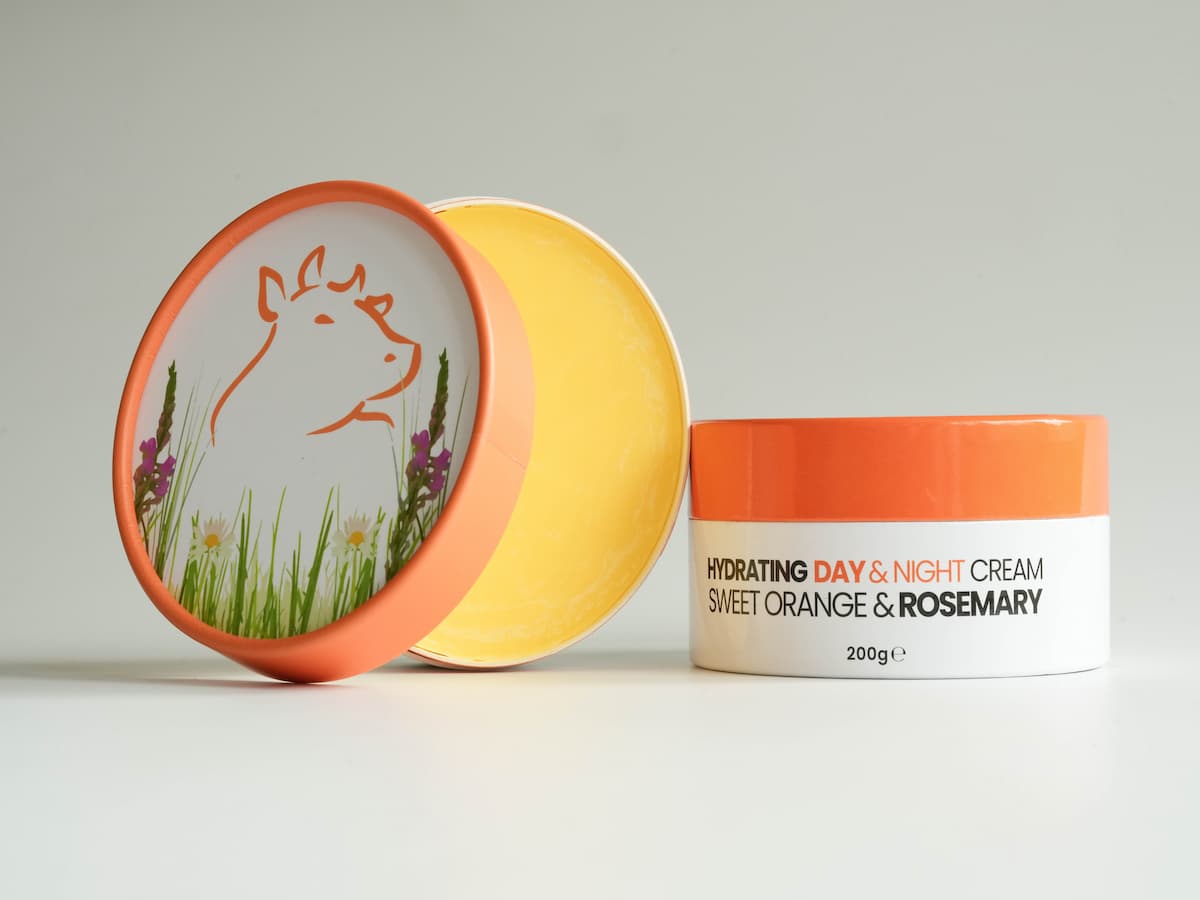 Soft orange and white tallow skincare cream with organic ingredients and a cute cow illustration.