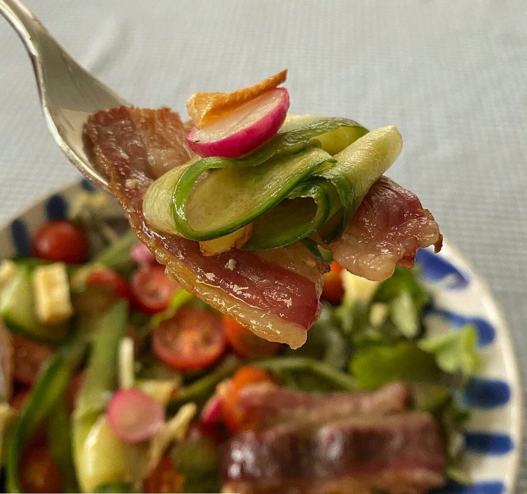 A detailed image of fresh salad ingredients with bacon and vegetables, emphasizing organic and natur.