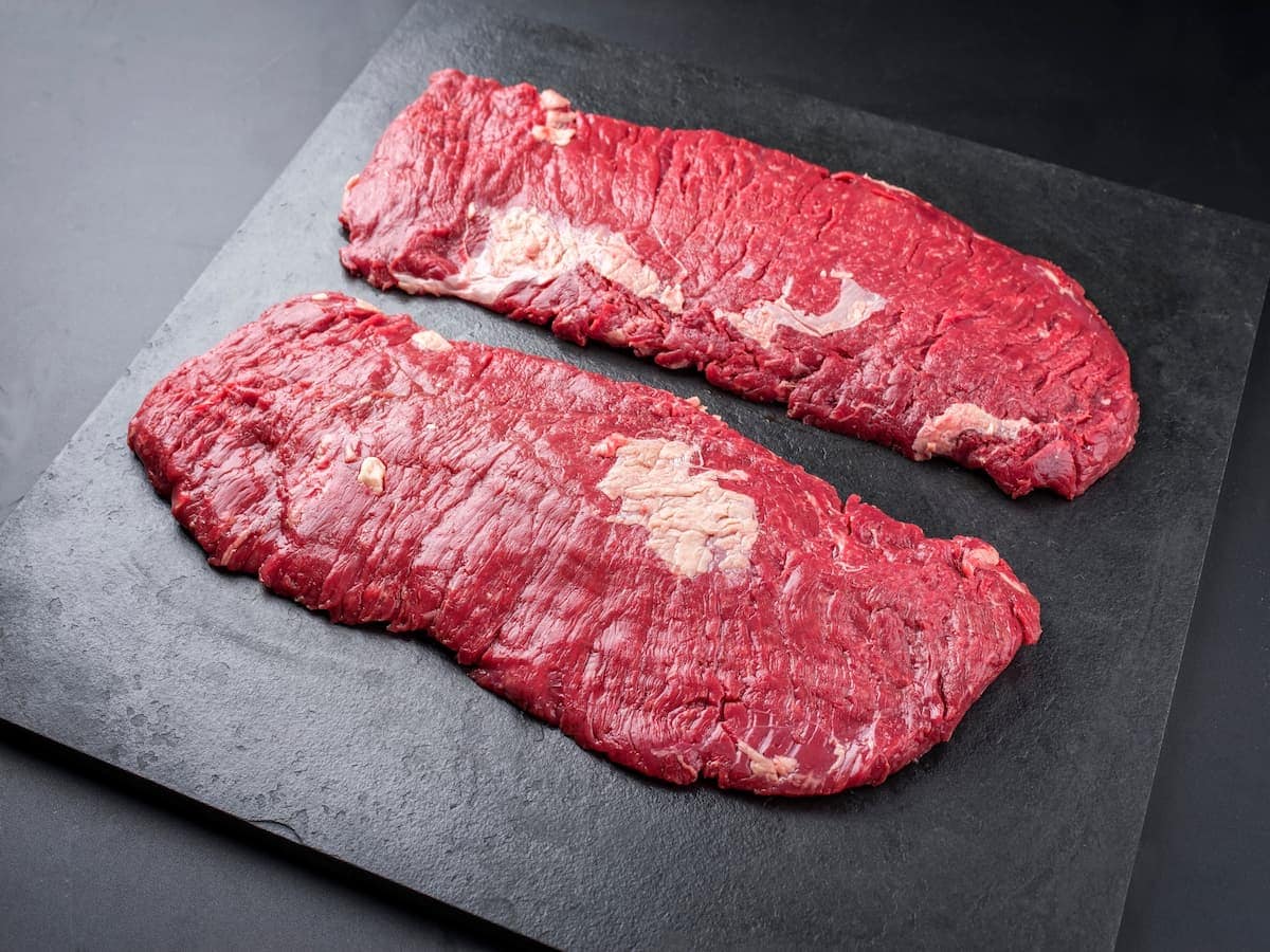 Grass-fed beef tallow slabs on a black slate surface, highlighting natural organic skincare ingredie.