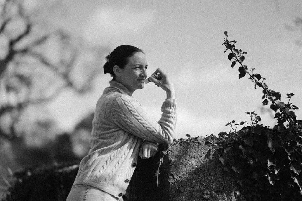 A woman enjoying the natural scenery at Hayes Meadow, surrounded by trees and greenery.