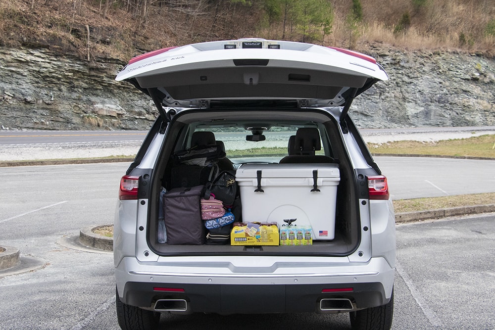 A Stress-Free Family Road Trip Packing List A chevy traverse with its tailgate up. You can see an orca cooler, drinks, and luggage. Food for road trips is a must on any family road trip packing list.