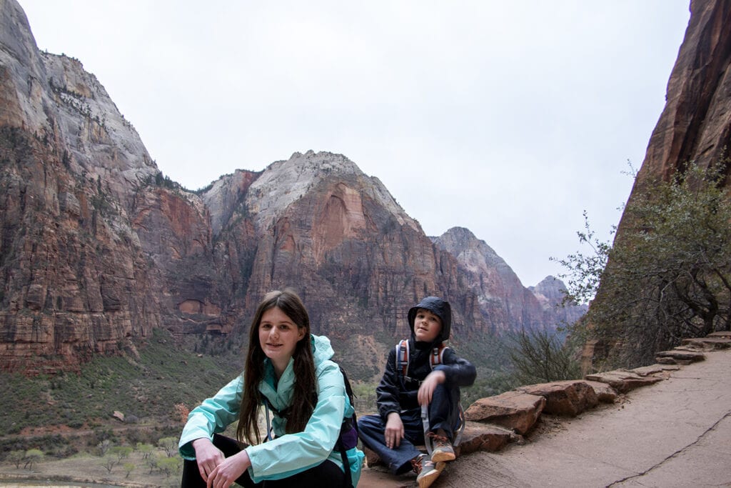 What to Pack for Zion National Park: A family-friendly Guide Kids resting while hiking to Scout's Lookout in Zion National Park
