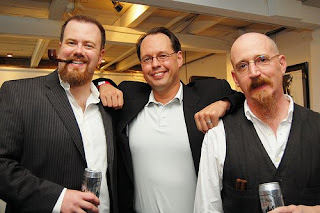 Group of professional men smiling at a corporate event, showcasing networking and collaboration.