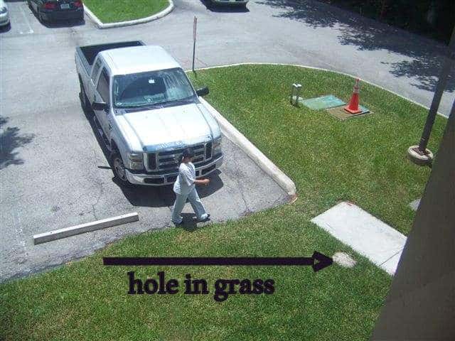 Hole covered with grass overgrowth at a office building in Doral, Miami-Dade County, Florida