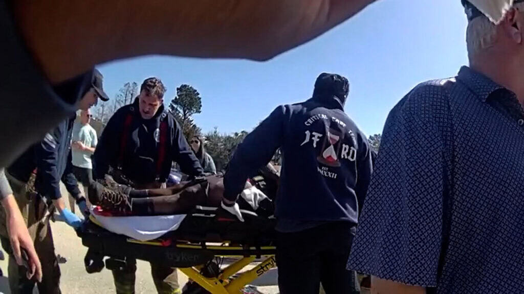 paramedics putting crash victim on a stretcher on the highway. 
