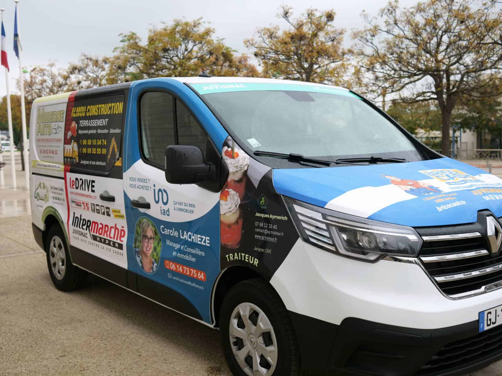 Vue de côté du mini-bus municipal, avec enseignes publicitaires des commerçants financeurs