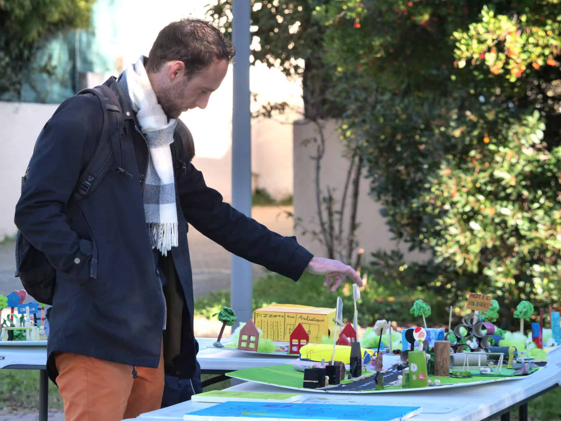 Un enfant observe une maquette du quartier des Constellations à Juvignac 