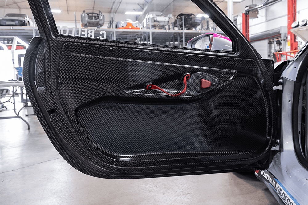 Close-up of Porsche 911 Cup Car interior door with carbon fiber finish.