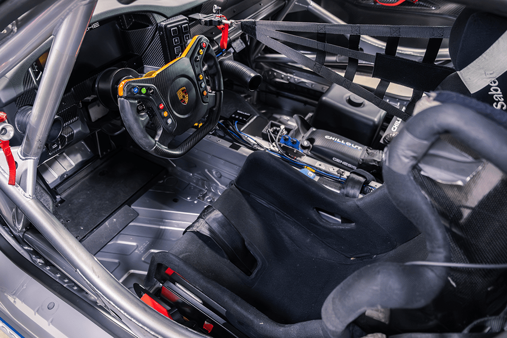 Racing car interior with racing seat, steering wheel, and dashboard details.
