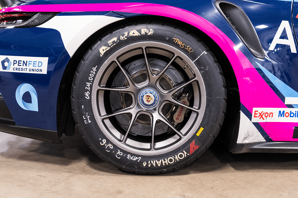 Close-up of a racing Porsche 911 Cup Car wheel with Yokohama tire and pink accents.